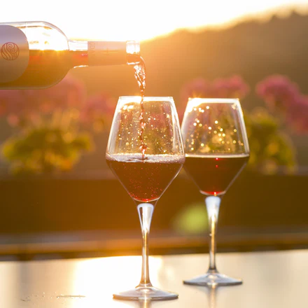 Vin rouge servi au soleil couchant, en terrasse